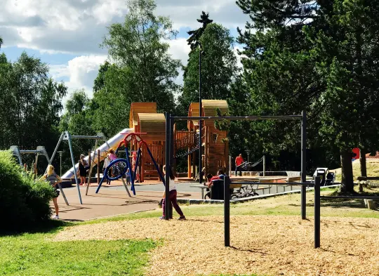 Bilde av en lekepark med husker, sklie og klatrestativ.