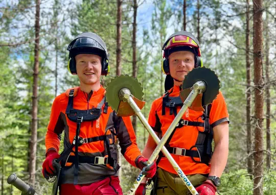 Bilde av to gutter som rydder i skogen. 