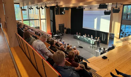 Oversiktsbilde av auditoriet på Glommasvingen skole hvor publikum lytter til at panelet svarer på spørsmål