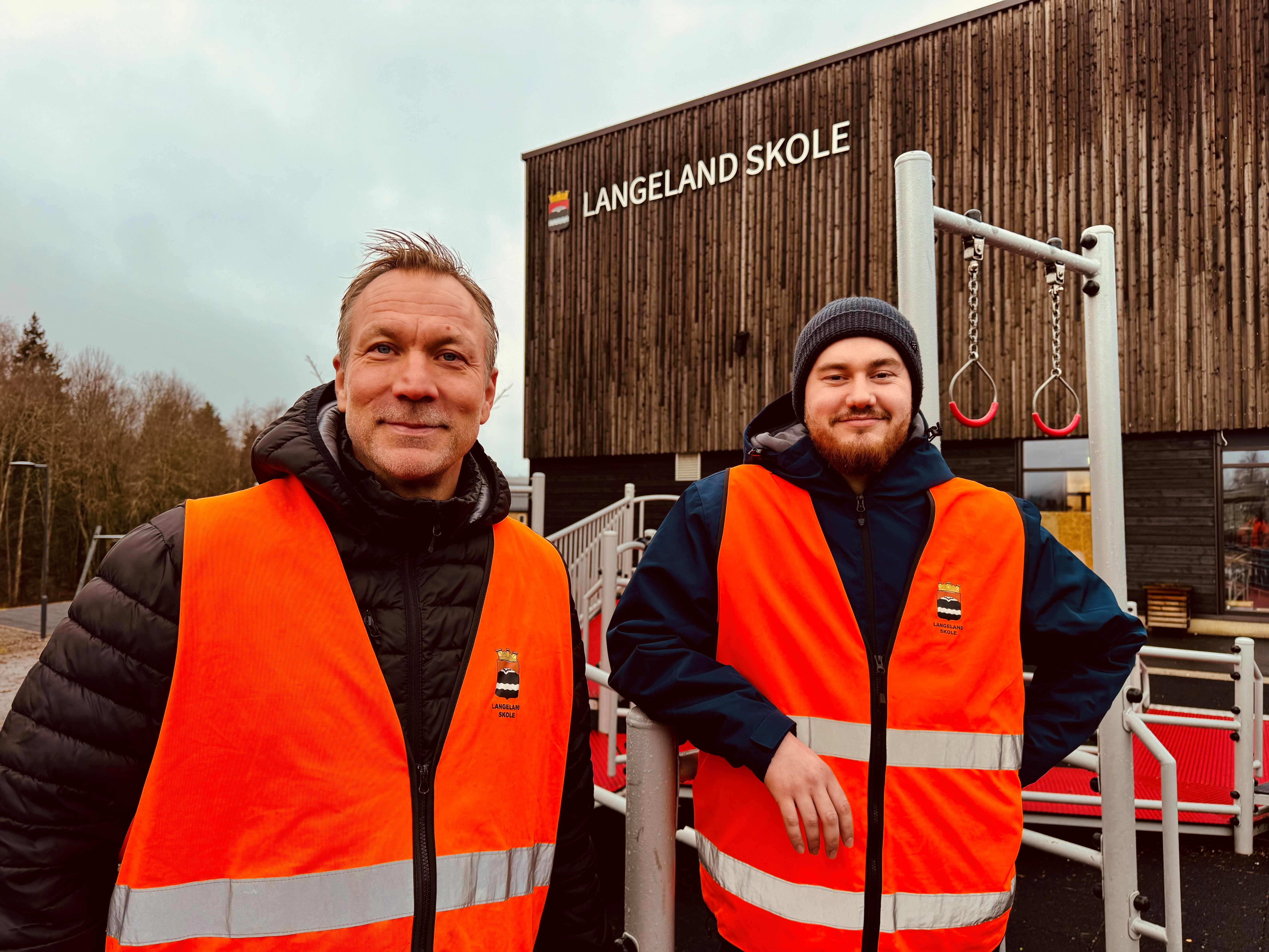 Bilde av Martin og Jerry som står foran Langeland skole.