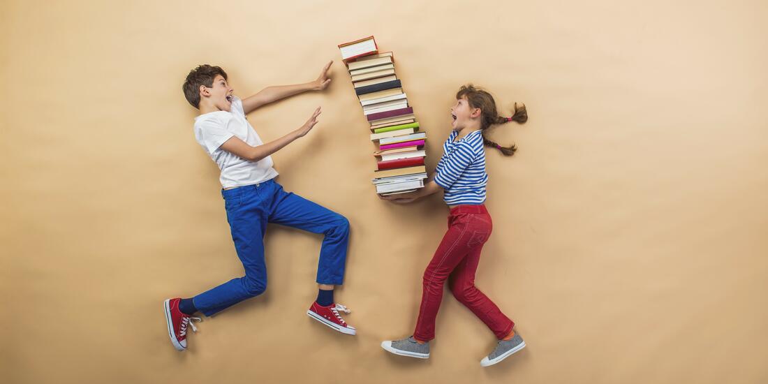 Viser et bilde av en gutt og jente. Jenta holder en stabel med bøker som er på vei til å falle på gutten. Et humoristisk med to elever som har det gøy på skolen.