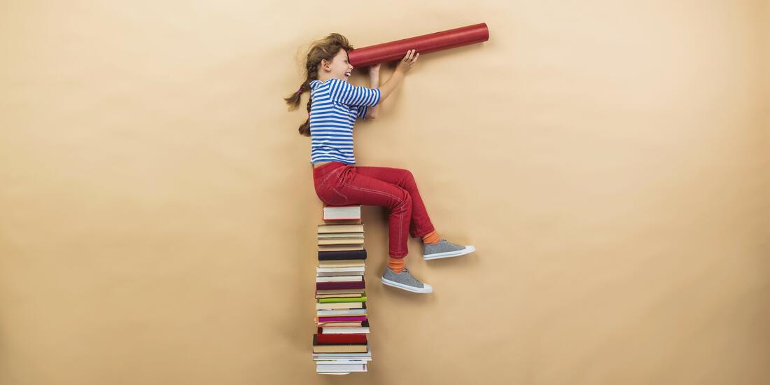 Bilde av ei jente som sitter på en stabel av bøker. Hun har en stor papirrull som hun titter igjennom - litt på søken etter og ser etter noe.