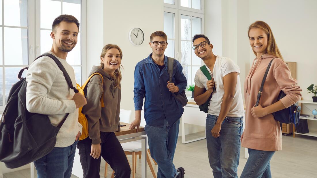 Bilde av 5 studenter, 3 gutter og to jenter, med sekk på ryggen i et klasserom. Bilde av 5 studenter, 3 gutter og to jenter, med sekk på ryggen i et klasserom.