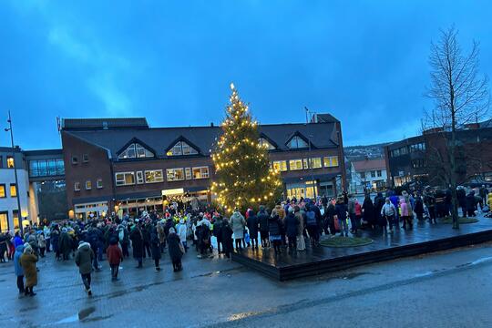 Bilde av barnehagebarn med foreldre som går rundt juletreet på Rådhusplassen under julegrantenning.