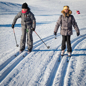 To jenter som har lånt skiutstyr på BUA og er ute og går på ski i skiløype.