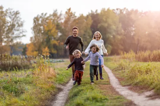 Barnefamilie som går tur på en grønn traktorveg.